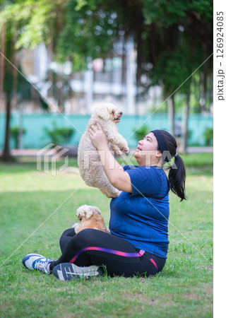 Young chinese woman outdoors holding dog 126924085