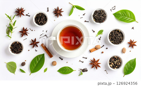 Cup of black tea surrounded by various spices and tea leaves on white background 126924356