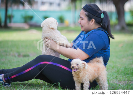 Young chinese woman outdoors holding dog Young chinese woman outdoors holding dog 126924447