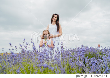 In the lavender field, a mother and her daughter are together In the lavender field, a mother and her daughter are together 126925131