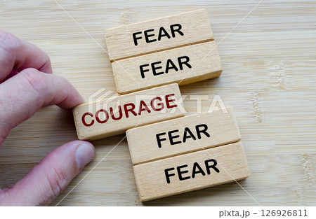 Fear and Courage in Contrast, a visual metaphor showing the inner conflict between fear and courage using wooden blocks 126926811