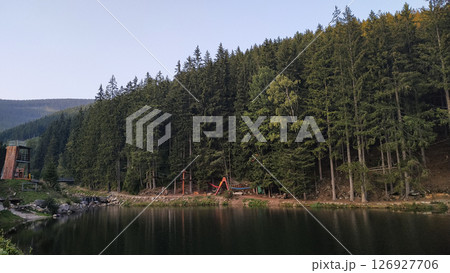 Lake reflecting pine forest and adventure park near snezka mountain in czechia in august 126927706