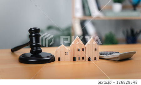 Gavel, houses, calculator. Symbolizes housing law, property valuation, and real estate transactions. Ideal for auctions, legal proceedings, financial decisions in the housing market and related laws. 126928348