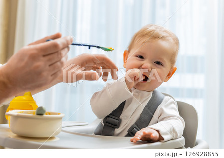 Father and a cute little baby boy having breakfast in the kitchen 126928855