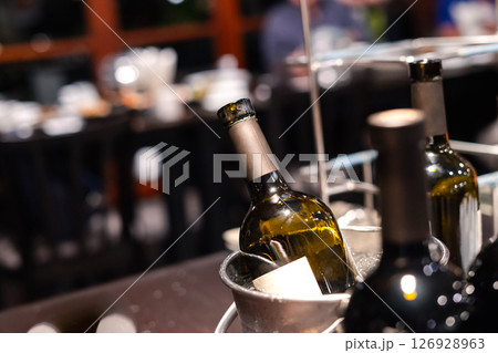 close-up of red wine bottle in ice bucket on romantic table, background out of focus 126928963