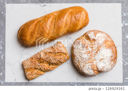 Assortment of freshly baked bread with napkin on rustic table top view. Healthy unleavened bread. French bread 126929161