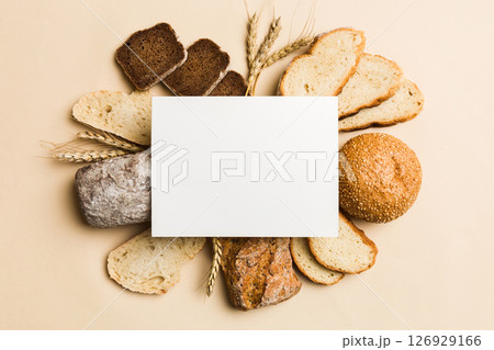 Minimalist paper blank mockup on background of Types of homemade bread. Different kinds of fresh bread as background, top view with space for your text or design 126929166