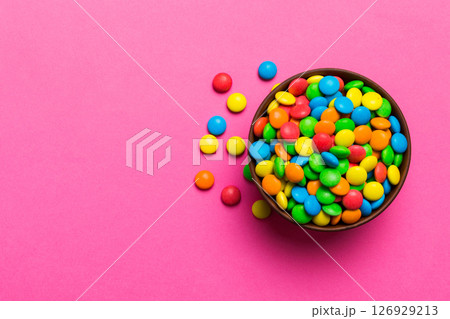 Multicolored candies in a bowl on a colored background. birthday and holiday concept. Top view with copy space Multicolored candies in a bowl on a colored background. birthday and holiday concept. Top view with copy space 126929213
