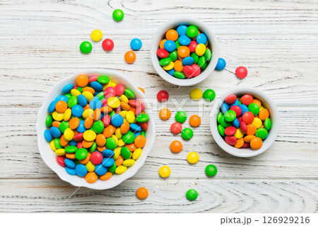 different colored round candy in bowl and jars. Top view of large variety sweets and candies with copy space 126929216