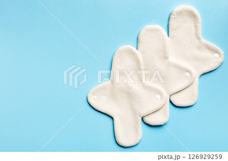 Eco-friendly reusable fabric women's pads. set of colorful bright reusable menstrual pads. zero waste woman periods concept top view with copy space Eco-friendly reusable fabric women's pads. set of colorful bright reusable menstrual pads. zero waste woman periods concept top view with copy space 126929259