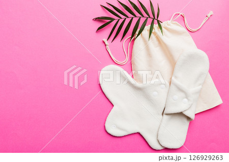 lean feminine sanitary napkin with green leaf. Absence of menstruation in woman. Minimal concept of female menopause. Copy space top view 126929263