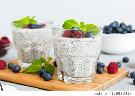 Healthy breakfast or morning with chia seeds vanilla pudding raspberry and blueberry berries on table background, vegetarian food, diet and health concept. Chia pudding with raspberry and blueberry Healthy breakfast or morning with chia seeds vanilla pudding raspberry and blueberry berries on table background, vegetarian food, diet and health concept. Chia pudding with raspberry and blueberry 126929316