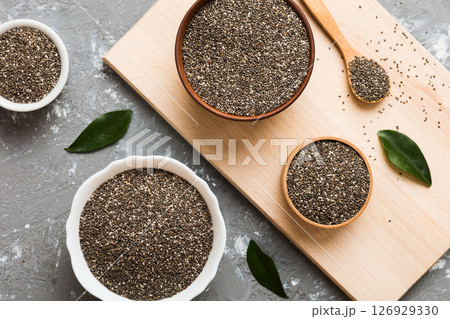 Chia seeds in bowl and spoon on colored background. Healthy Salvia hispanica in small bowl. Healthy superfood Chia seeds in bowl and spoon on colored background. Healthy Salvia hispanica in small bowl. Healthy superfood 126929330