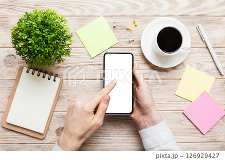 Top view of woman hands holding smart phone with blank copy space screen for your text message or information content. woman hand using phone white screen on top view 126929427