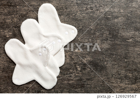 Eco-friendly reusable fabric women's pads. set of colorful bright reusable menstrual pads. zero waste woman periods concept top view with copy space Eco-friendly reusable fabric women's pads. set of colorful bright reusable menstrual pads. zero waste woman periods concept top view with copy space 126929567