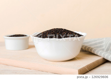 quinoa seeds in bowl on colored background. Healthy kinwa in small bowl. Healthy superfood quinoa seeds in bowl on colored background. Healthy kinwa in small bowl. Healthy superfood 126929606