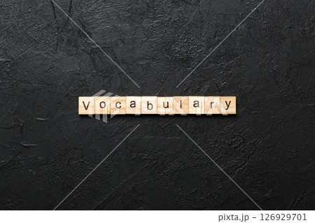 vocabulary word written on wood block. vocabulary text on table, concept 126929701