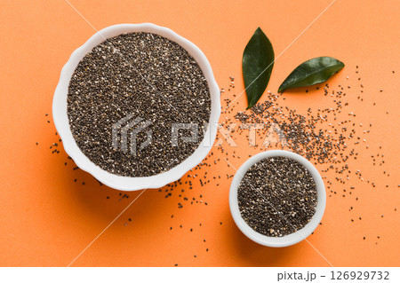 Chia seeds in bowl on colored background. Healthy Salvia hispanica in small bowl. Healthy superfood Chia seeds in bowl on colored background. Healthy Salvia hispanica in small bowl. Healthy superfood 126929732