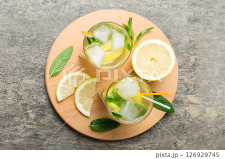 Caipirinha, Mojito cocktail, vodka or soda drink with lime, mint and straw on table background. Refreshing beverage with mint and lime in glass top view flat lay Caipirinha, Mojito cocktail, vodka or soda drink with lime, mint and straw on table background. Refreshing beverage with mint and lime in glass top view flat lay 126929745