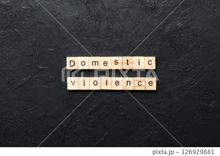 Domestic violence word written on wood block. Domestic violence text on cement table for your desing, Top view concept 126929881