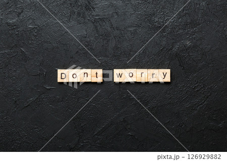 Don't worry word written on wood block. Don't worry text on cement table for your desing, Top view concept Don't worry word written on wood block. Don't worry text on cement table for your desing, Top view concept 126929882