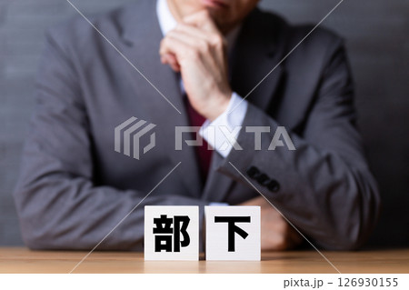 部下のブロックとスーツを着て悩むミドル男性ビジネスマン 126930155