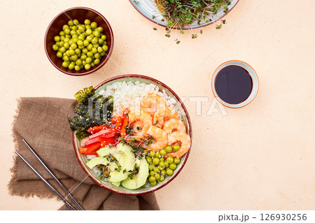 A poke bowl with shrimp, avocado, pepper, green peace and micro greens 126930256