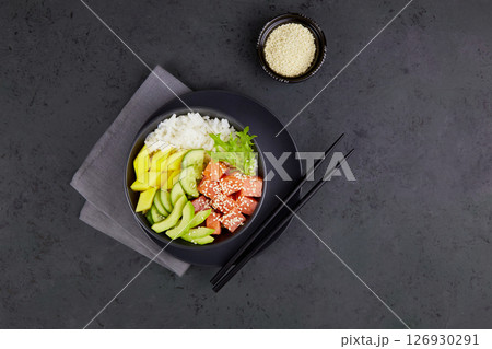 Poke bowl with salmon, rice, avocado, cucumber, mango, greens. Poke bowl with salmon, rice, avocado, cucumber, mango, greens. 126930291