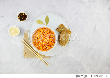 Spicy pickled carrots in a bowl on a grey background, spicy Korean appetizer. 126930304