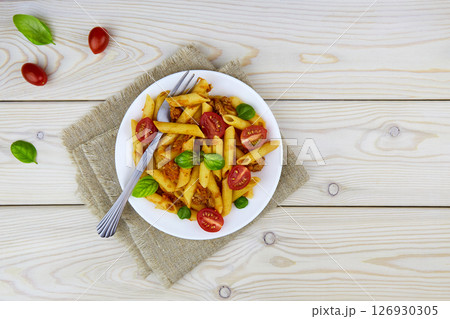 Classic Italian bolognese pasta penne with tomatoes, basil 126930305