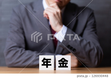年金のブロックとスーツを着て悩むミドル男性ビジネスマン 年金のブロックとスーツを着て悩むミドル男性ビジネスマン 126930448