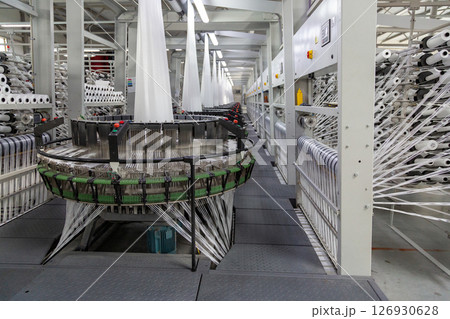 Interior of a factory shop. Equipment for weaving polypropylene fabric. Interior of a factory shop. Equipment for weaving polypropylene fabric. 126930628