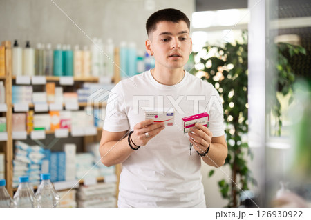Young man buys paracetamol pills at pharmacy 126930922