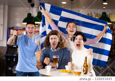 Enthusiastic Greek fans scream with joy in beer bar. Greece win Enthusiastic Greek fans scream with joy in beer bar. Greece win 126931645