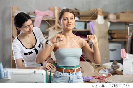 dressmaker takes measurements from the client dressmaker takes measurements from the client 126931778