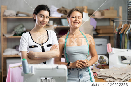 dressmakers are standing in the workshop and smiling dressmakers are standing in the workshop and smiling 126932228