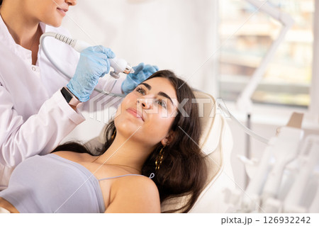 Young girl undergoing skin therapy session with application of atomized nutrients Young girl undergoing skin therapy session with application of atomized nutrients 126932242