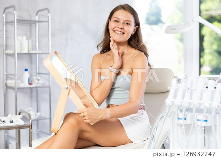woman gazes at herself in mirror woman gazes at herself in mirror 126932247