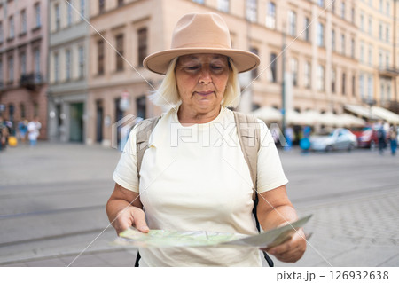 Senior woman exploring the city with a map, sightseeing in the square. 126932638