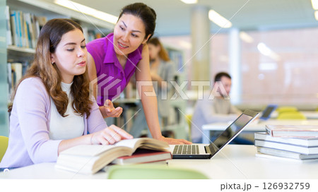 Two woman students, preparing a report on a laptop 126932759
