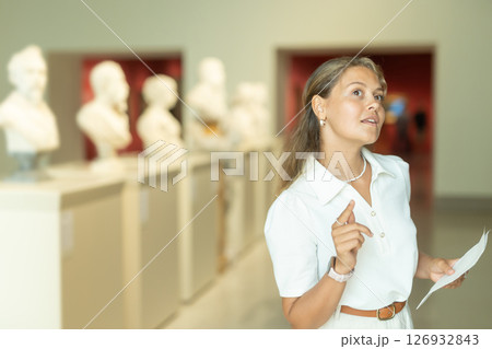 Portrait of attractive woman visiting sculpture hall in historical museum and looking at exhibits 126932843