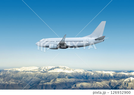 White modern jet plane flies over snow covered mountains White modern jet plane flies over snow covered mountains 126932900