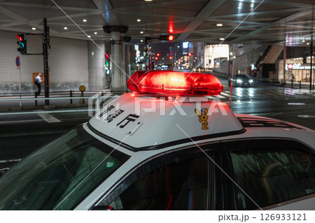 夜の繁華街 赤色灯を点灯したパトカー 夜の繁華街 赤色灯を点灯したパトカー 126933121