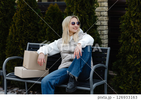 Young Woman Relaxing on Bench After Receiving Packages 126933163