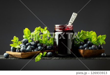 Blueberry jam and fresh berries with leaves. Blueberry jam and fresh berries with leaves. 126933913