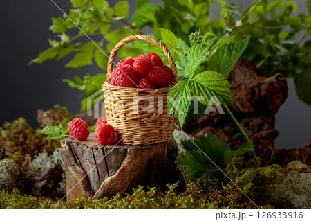 Small wicker basket filled with fresh, ripe raspberries. Small wicker basket filled with fresh, ripe raspberries. 126933916