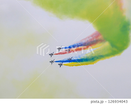J-10 Acrobatic airshow team from China Air Force on formations with colorful smokes venting from the plane. 126934043