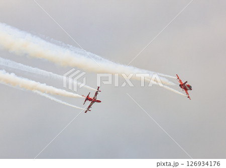 HAWK MK132 Acrobatic airshow team from India Air Force on formations with colorful smokes venting from the plane. 126934176