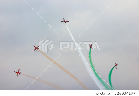 HAWK MK132 Acrobatic airshow team from India Air Force on formations with colorful smokes venting from the plane. 126934177