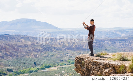Tourist taking pictures of gorafe desert landscape from a cliff 126934224